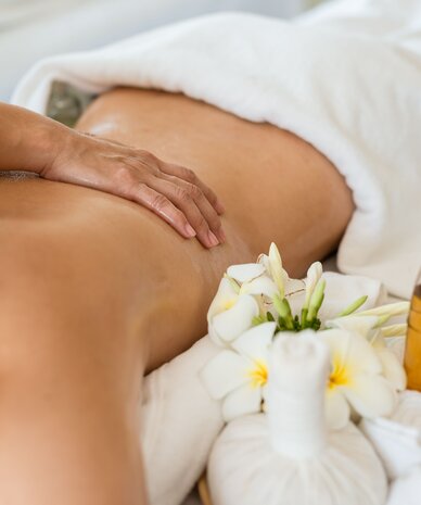 Back massage in a spa with oil bottles and flowers | © X-Reflex naja