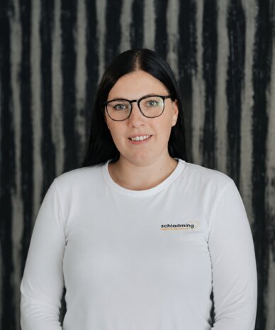 Porträt einer Frau mit Brille in weißem Hemd.