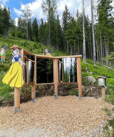 Wooden display with Snow White cutouts and mirrors among trees