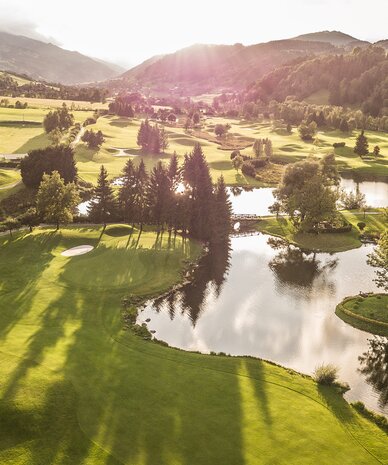 Aerial view of a golf course with ponds and an island