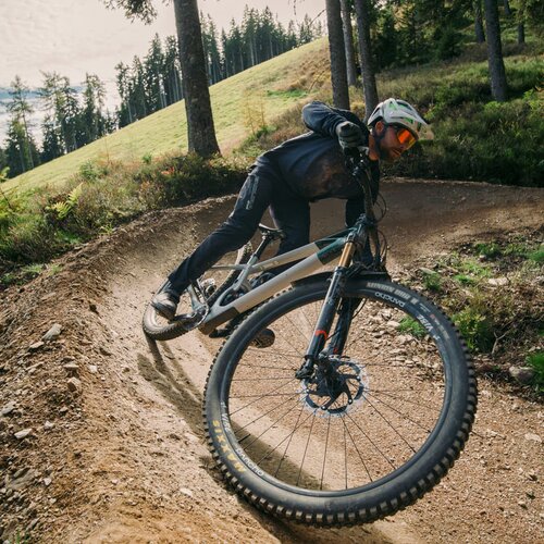 Mountain biker takes a sharp turn on a dirt forest trail