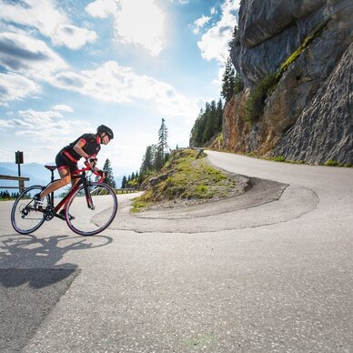 Cyclist riding a road bike on a winding mountain road