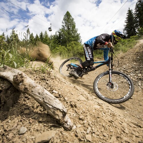 Mountain biker in blue kit carving turn on rocky dirt trail | © Roland Haschka/Young Mountain Marketing