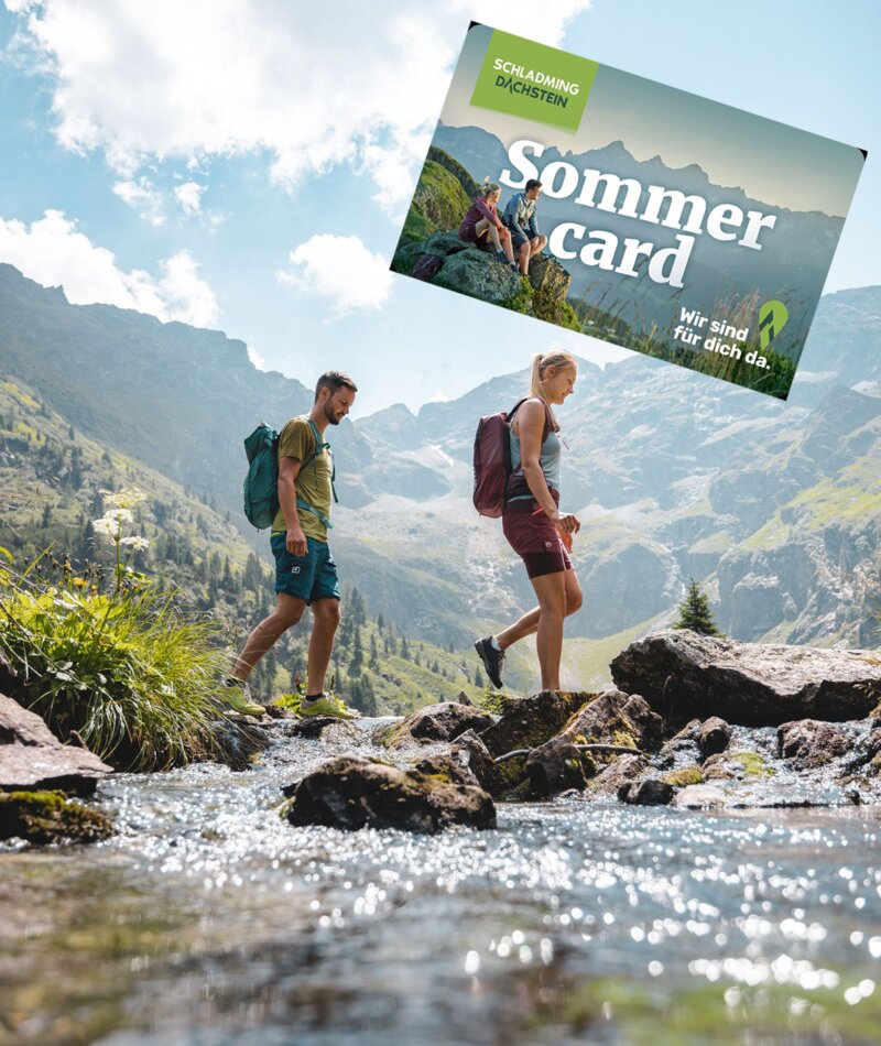 Hikers cross rocky stream beneath mountains; Sommer Card banner.