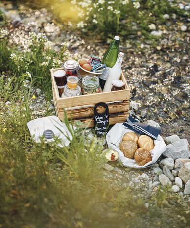 Picnic setup on rocky bank; sign reads Guten Morgen. | © RAPHAELGABAUER.COM