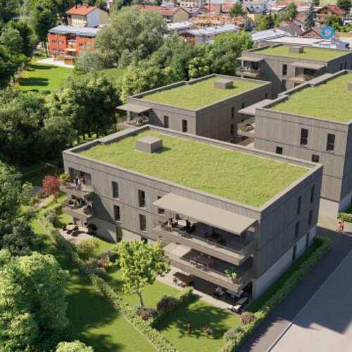 Luftaufnahme moderner Wohnanlagen mit begrünten Dächern und Bäumen