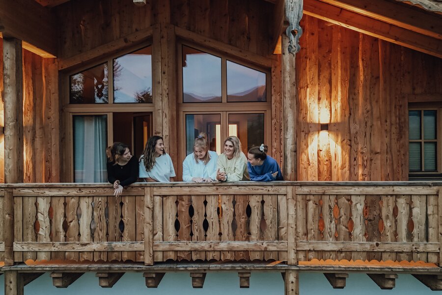 Gruppe von Freunden auf einem rustikalen Holzbalkon