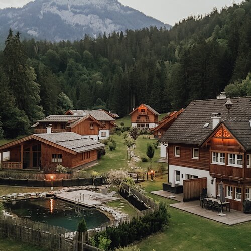 Alpines Dorf mit Holzhäusern und Teich