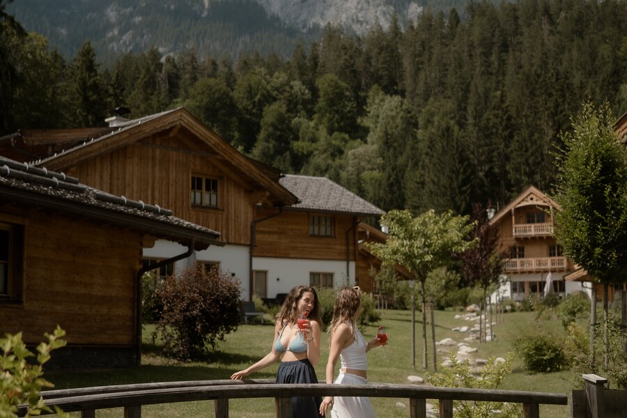 Two women in summer dresses on a wooden bridge