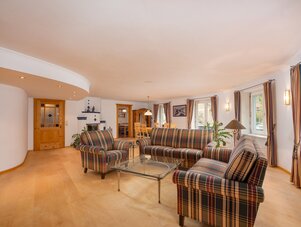 Geräumiges Wohnzimmer mit karierten Sofas und Glastisch