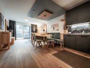 Open-concept living area with dining table, bench seating, and kitchen