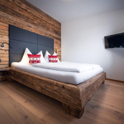 Rustic wooden bedroom with platform bed and white bedding