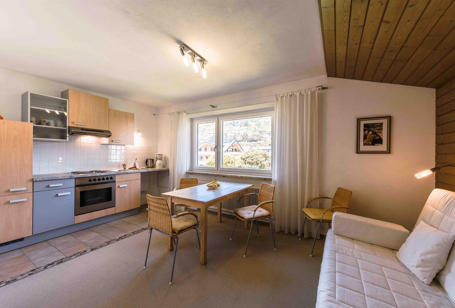 Kitchen and dining area with wooden ceiling and window