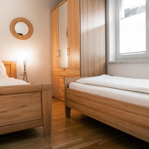 Two wooden twin beds in a bright bedroom
