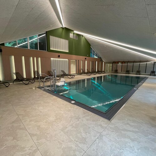 Indoor pool with lounge chairs along the deck