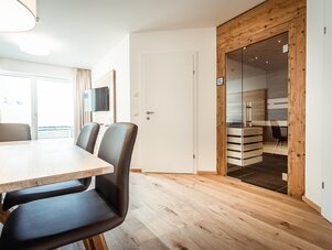 Dining area with wooden floor and glass sauna door