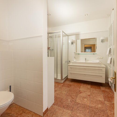 Bright white bathroom featuring shower, sink, and toilet