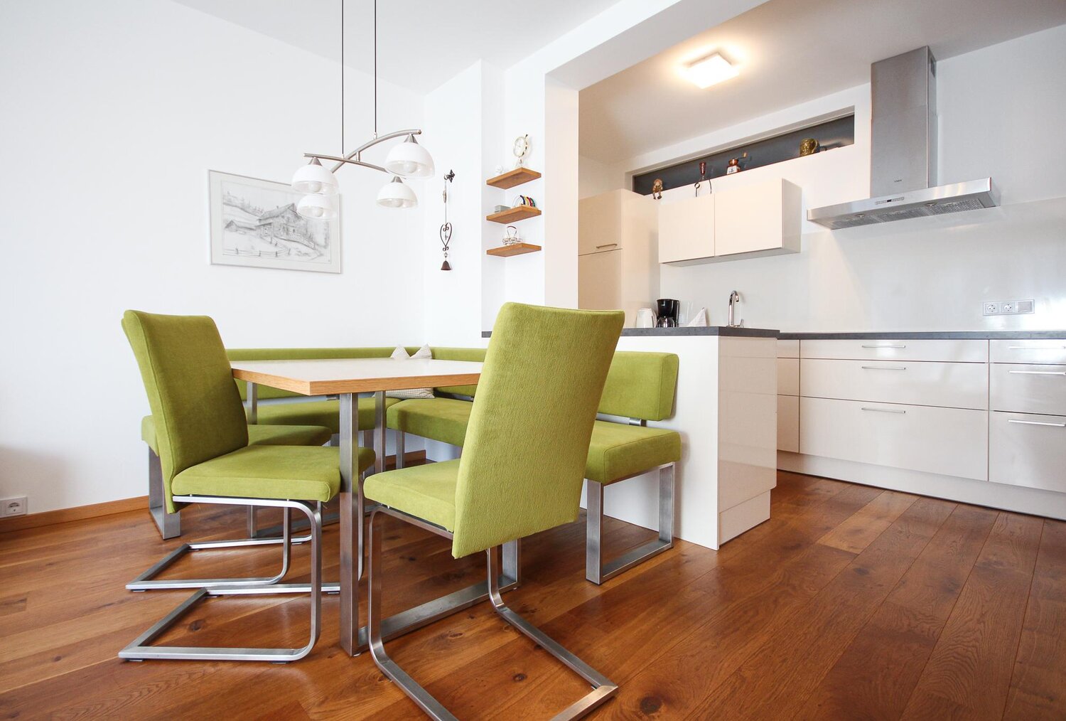 Modern kitchen and dining area with green chairs | © SCHLADMING-APPARTEMENTS