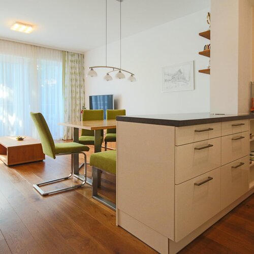 Open plan living area with kitchen island and green chairs