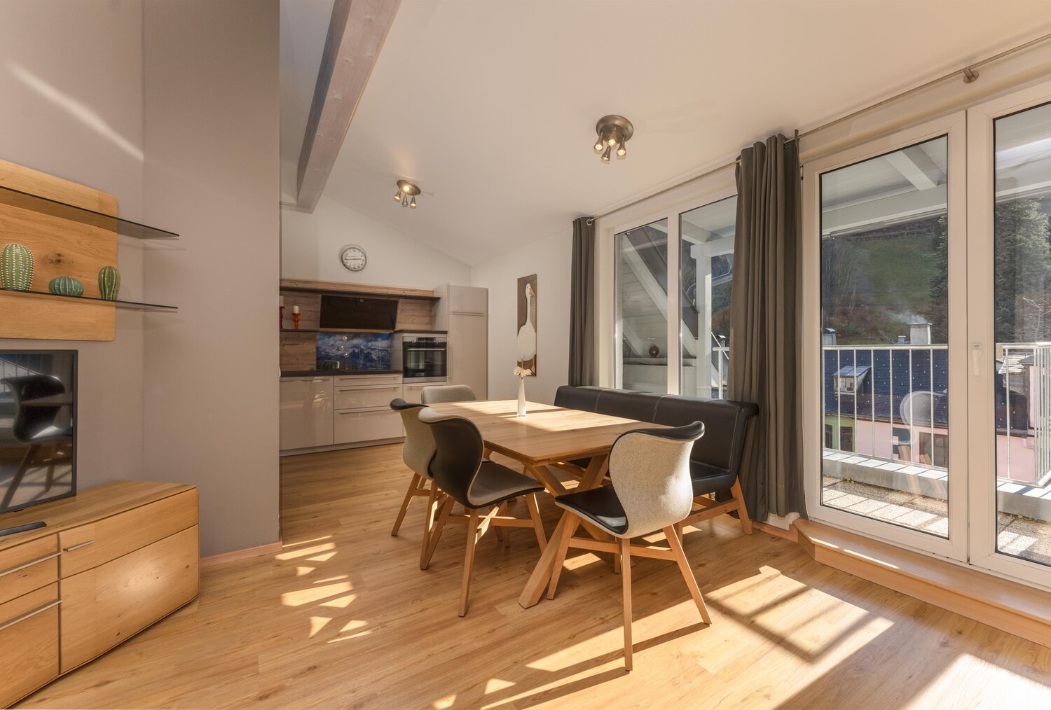 Bright open-plan dining area with wooden floor and glass doors