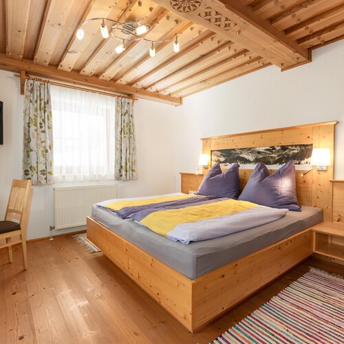 Cozy wooden bedroom with large bed, nightstands, and lamps