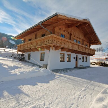 Snowy alpine chalet with large wooden balcony
