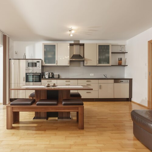 Modern open-plan kitchen with dining table and benches