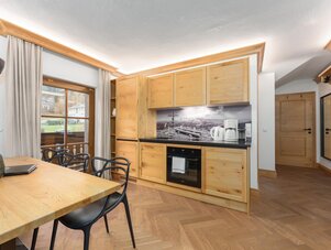 Bright wooden kitchen with dining table and window