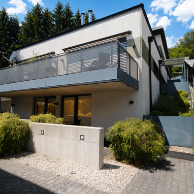 Modern two-story building with glass balcony and landscaped grounds