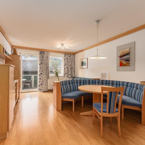 Bright living area with blue striped seating and round table