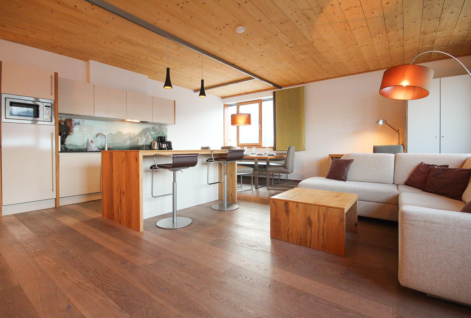 Open-plan living area with kitchen island and sofa | © SCHLADMING-APPARTEMENTS
