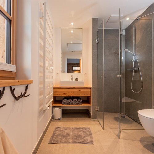 Modern bathroom with glass shower and wooden vanity