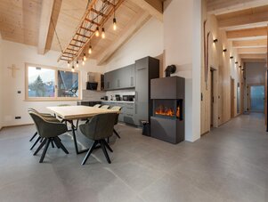 Open-plan chalet kitchen with dining area and fireplace.