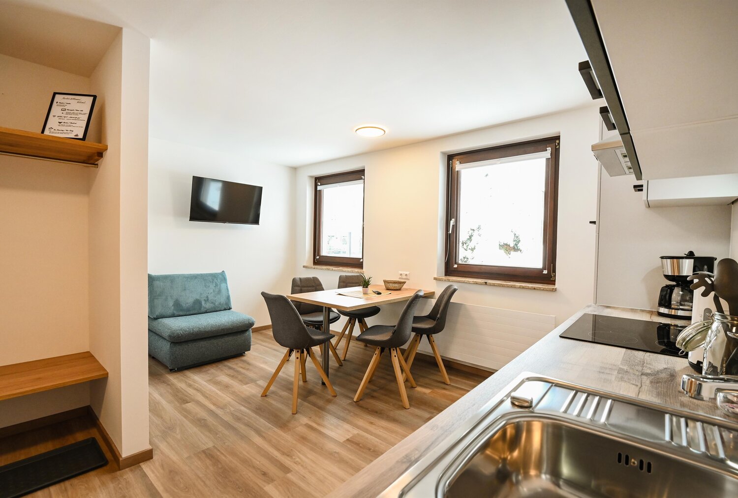 Open-plan living area with sofa, dining table, and kitchen