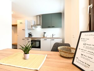 Bright modern kitchenette with gray wall cabinets and dining table