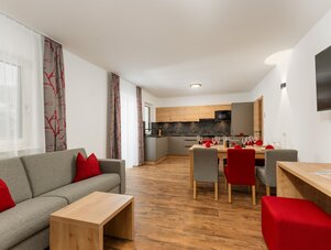 Open living area with grey sofa and dining table.
