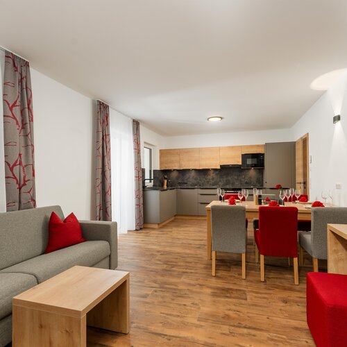 Open living area with grey sofa and dining table.