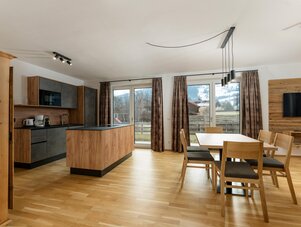Open-plan kitchen and dining area with wooden furniture.