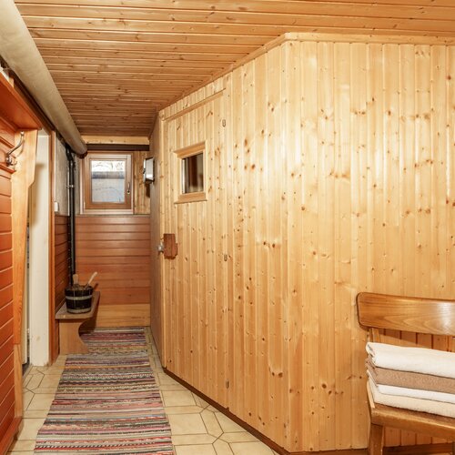 Narrow wooden hallway with coat hooks and towels