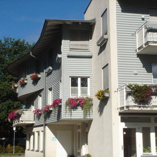 Multi-story apartment building with balconies and flowers