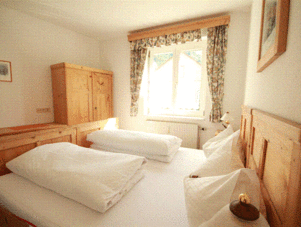 Twin beds in a wooden bedroom with window