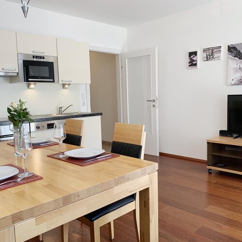 Open-plan kitchen and dining area with wooden table