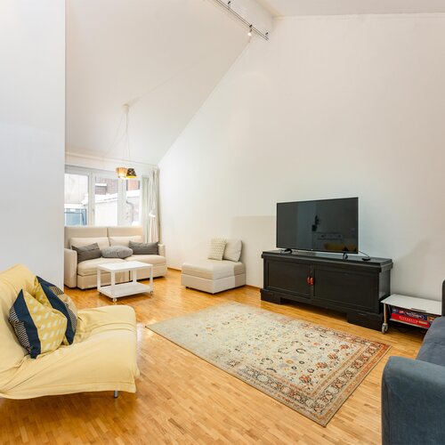 Bright living room with yellow lounge chair and sofas