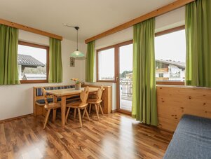 Cozy dining nook with wooden table and green curtains