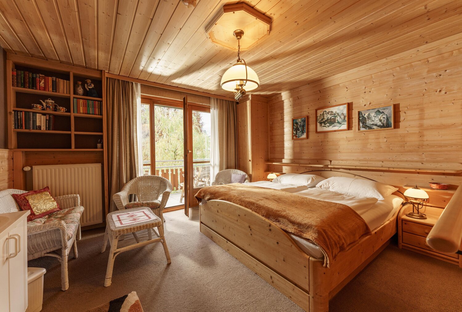 Wood-paneled bedroom with a large bed and balcony doors