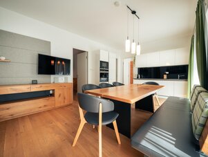 Open-plan dining area with wooden table and black chairs