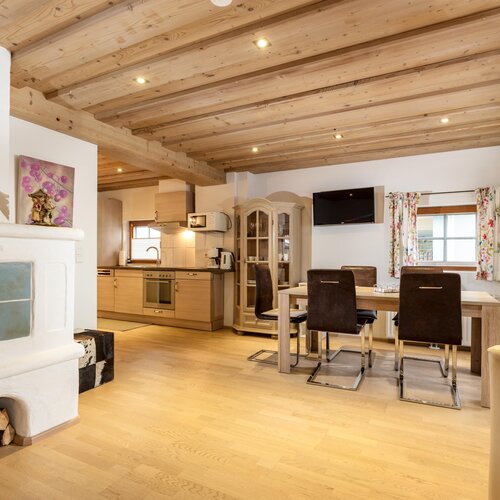 Open-plan living area with kitchen, dining table, and fireplace