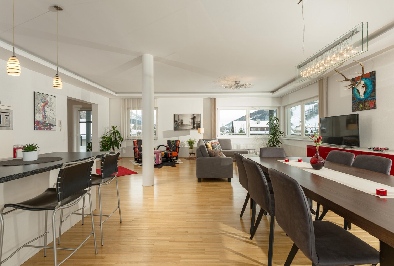 Open-plan kitchen, dining, and living area with large windows.