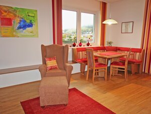 Living room with red-accent dining area and armchair
