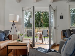 Living room with open glass doors to deck and outdoor seating